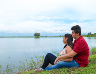 Heterosexual couple sitting by a lake