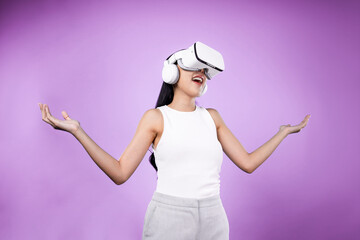 Smart female standing with pink background wearing VR headset connecting metaverse, futuristic...