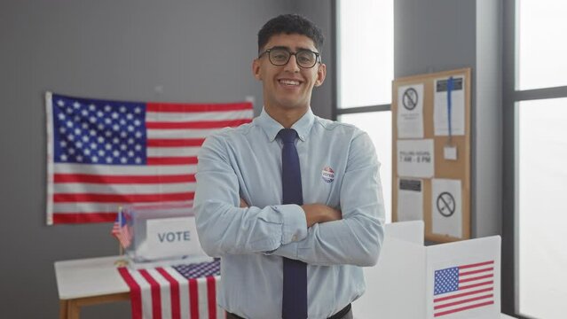 Young man with 'i voted' sticker stands confidently in a polling station with american flags.