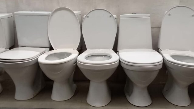 Various toilet bowls on the shop window. Wholesale and retail trade of sanitary ware. Different toilet bowls in the toilet and in the bathroom