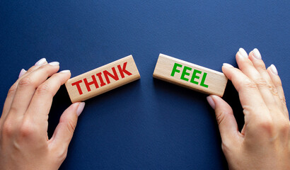 Think or Feel symbol. Concept word Think or Feel on wooden blocks. Businessman hand. Beautiful deep...