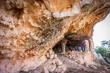 tourist in Sa Cova des Voltor, (the vulture cave), historic sandstone quarry, Petra, Majorca,...