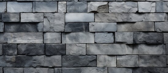A detailed closeup of a rectangular grey brick wall showcasing the intricate brickwork pattern. The monochrome photography highlights the texture of the building material