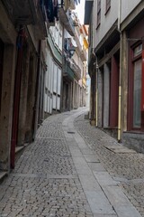 Fototapeta na wymiar Narrow street of the old town of Porto in Portugal - cobbled street - shop windows - no people