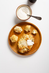 Overhead view  of roasted vegan steak cauliflowers healthy food on wooden plate