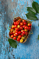 Top view of ripe cherries in a cardboard box on vintage surface