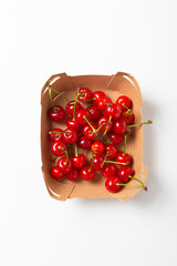 Top view of ripe cherries in a cardboard box