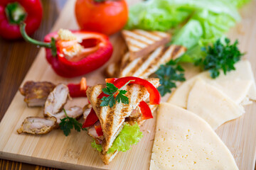 fried toast with chicken, salad, greens on a wooden table