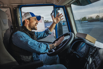 An angry truck driver is driving a truck and is annoyed with people who disturb the traffic