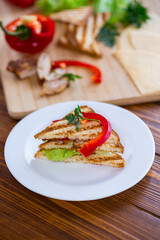 fried toast with chicken, salad, greens on a wooden table