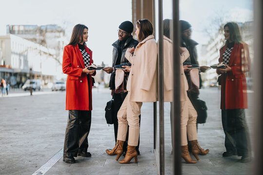 An image of young business partners in a casual meeting on a city sidewalk, reflecting cooperation and professional interaction.
