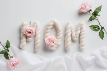 MOM word made with flower petals and leaves. Mother's day natural creative concept background. Social mockup.