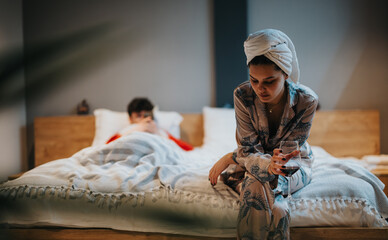 A contemplative moment as a woman in a robe sits with wine on her bed, with a sense of solitude