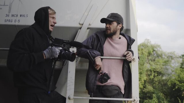 hobo bloggers climbing freight train with cameras