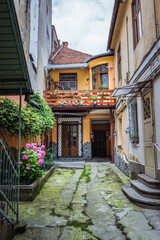 Fototapeta na wymiar Courtyard of townhouses next to Republic pedestrian street in Old Town of Brasov city, Romania