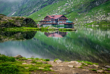 Fototapeta na wymiar Balea Lac Chalet mountain guesthouse over Balea Lake next to Transfagarasan road in Carpathian Mountains, Romania