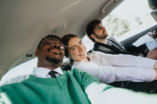 Three business professionals carpooling, enjoying a casual conversation while traveling in a vehicle. A sense of community and shared responsibility.
