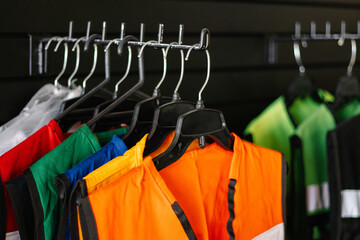 Chalecos de seguridad colgados en ganchos de ropa 