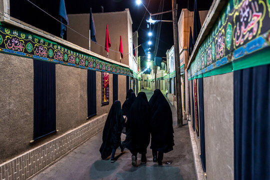 Women on Old Town street decorated for Muharram in Kashan, Iran