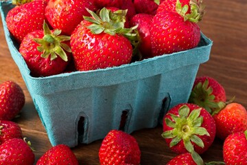 Close up overflowing quart basket of strawberries - obrazy, fototapety, plakaty