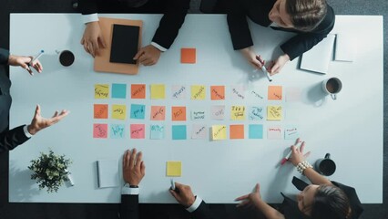 Business people looking and choosing at marketing idea written on sticky notes. Top view of project manager standing and.presenting strategy while investor listening at meeting room. Directorate.