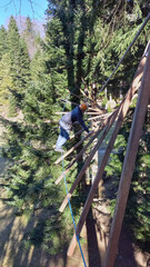 A man overcomes an obstacle in a rope park.