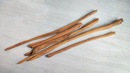 Pieces of dried cinnamon or Cinnamomum zeylanicum which is useful as a cooking spice and natural medicine, isolated on a patterned ceramic surface