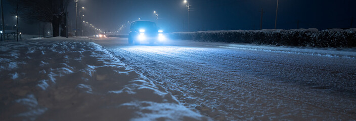 Driving in winter, car lights in the evening
