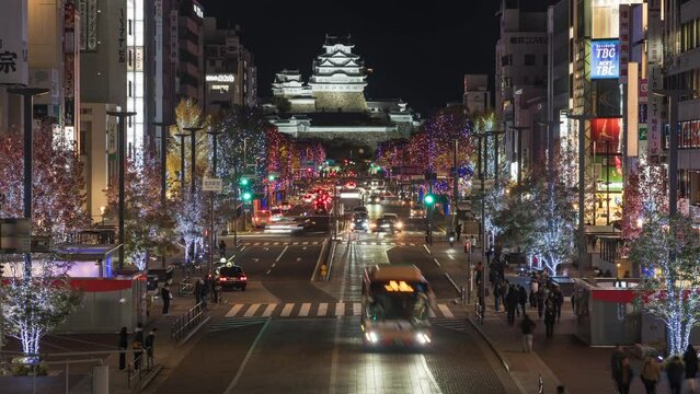Timelapse view of street traffic at night in Himeji city with historic landmark Himeji Castle in the background, Hyogo Prefecture, Japan, zoom out. 