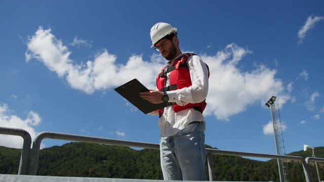 Man Construction manager with a notepad check the dam building on the mountains