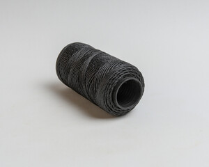 coil of black thread on white background
