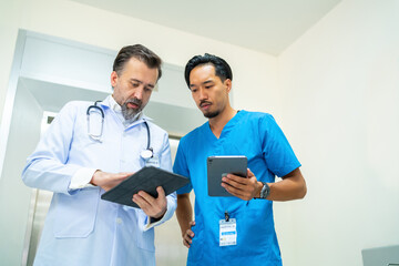 Fototapeta premium Specialized doctor medical center and hospital health care services. Group of doctor and nurse talking discussion about surgical and patient care during waiting for elevator in hospital corridor.