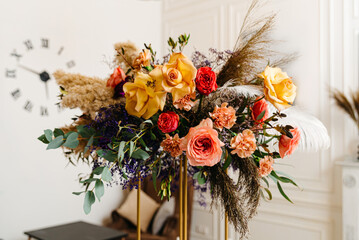 Elegant Floral Arrangement with Clock in Background. A vibrant bouquet of roses and wildflowers...