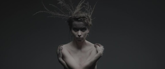 An enchantress dressed as mother nature performs dance like ritual