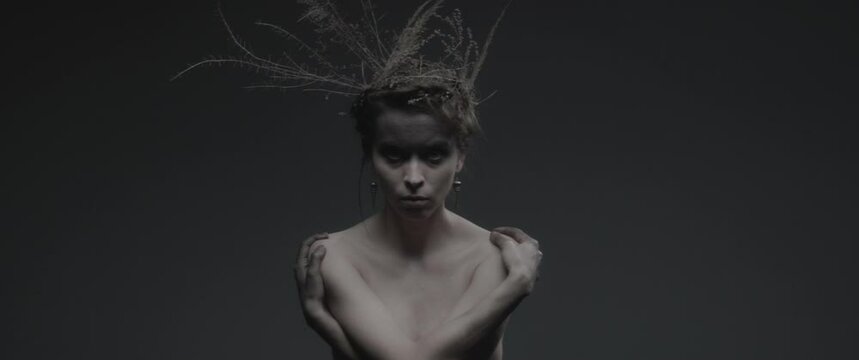 An enchantress dressed as mother nature performs dance like ritual