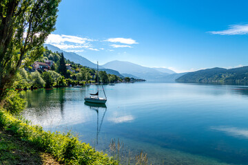 Serene Austrian Lake with Anchored Boat and Natural Frame
