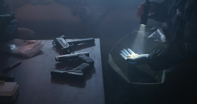 Crime Scene Investigators In Drug Den, Guns and Bullets. Officer Pull bullets from bag, Flash light in low light, Slow Motion