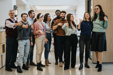 An inclusive team of businesspeople showing approval with thumbs up in a bright office environment, signaling positivity and agreement.