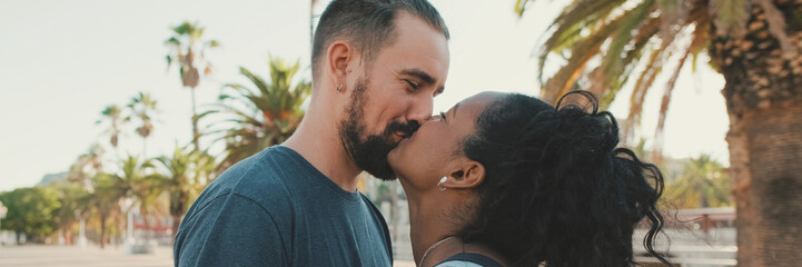 Close up, happy interracial family kisses outside, Panorama