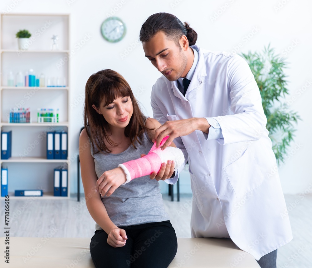 Wall mural young woman visiting male doctor traumatologist