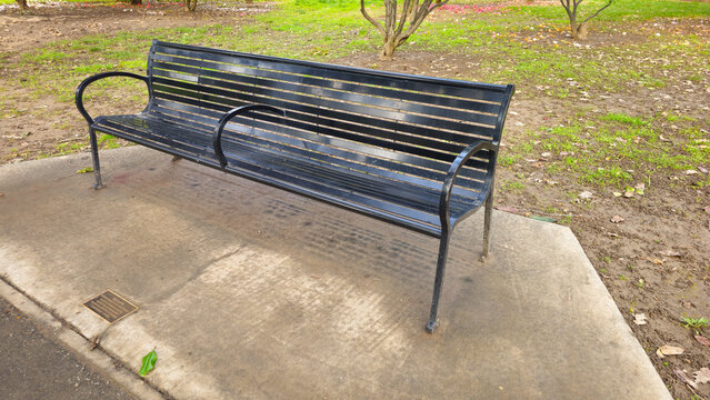 A black iron bench in the park.