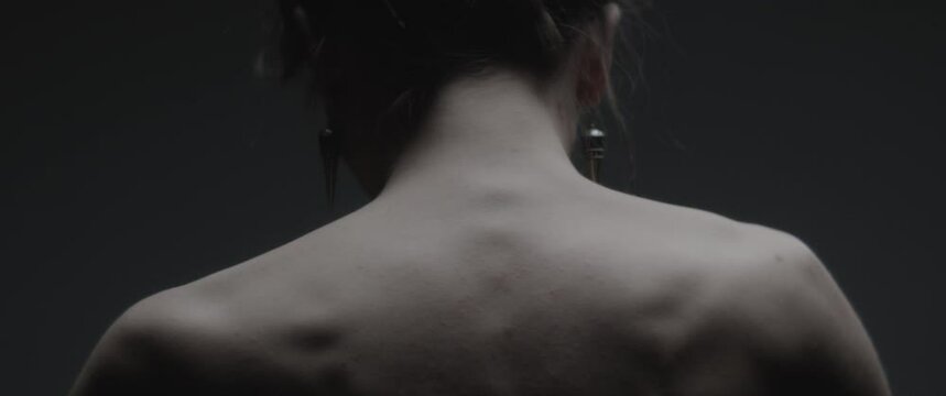 A young model dressed like mother nature performs slow ritual moves in a studio 