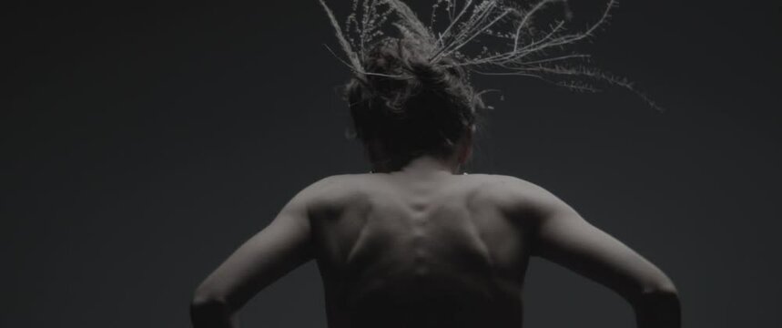 A model dressed like mother nature performs a ritual dance in a studio 
