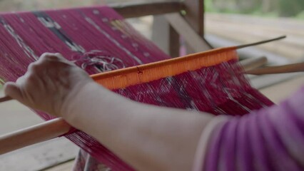 An Indonesian woman makes traditional woven fabric