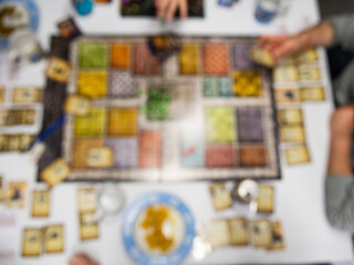 defocused board game from above with people playing - 771874883