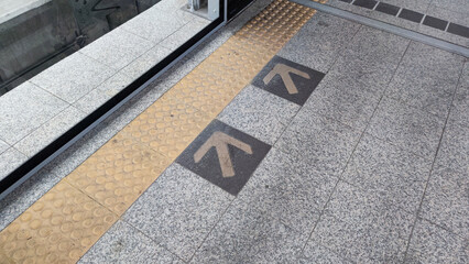 Directional markers on the platform guide passengers awaiting the sky train, with yellow arrows delineating the path