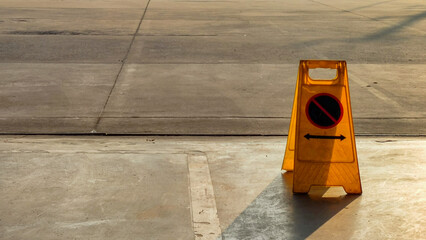 yellow wet floor sign on the ground next to an empty concrete area