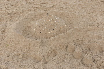Children's entertainment sand castle with seashells on the beach