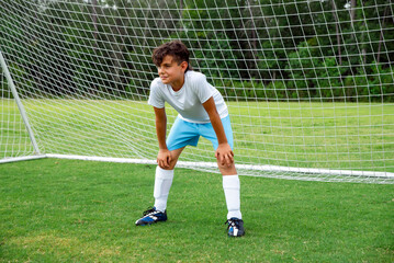 Male youth soccer goalkeeper standing ready to protect the goal during a game or practice