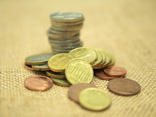 Stack of Mixed Coins on Burlap Fabric